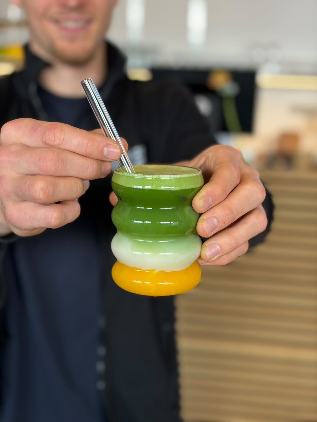 Mehrschichtiges Matcha-Mango-Getränk im Wellenglas